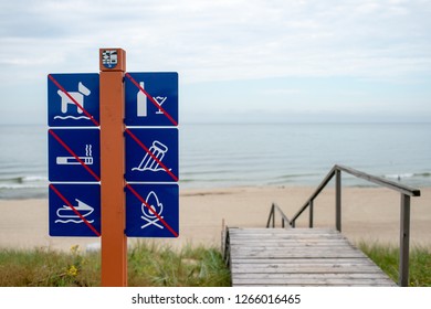 On the beach it is forbidden: walking Pets, drinking alcohol, Smoking, garbage, boating,bonfires. No dog. Please don't litter beach. warning blue signs with a red diagonal line on the behavior on sea - Shutterstock ID 1266016465