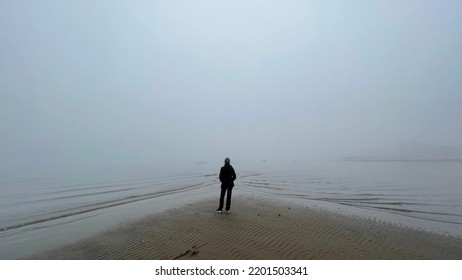 On The Beach Looking Out At The Misty Ocean