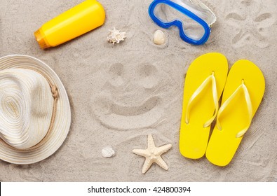 On The Beach In The Sand Drawing Smile With Beach Items, Top View. Summer Background