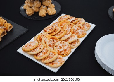 On a beautifully set table, a pristine white plate is artfully topped with a selection of delightful mini pizzas, showcasing an inviting and appetizing arrangement perfect for any gathering or meal - Powered by Shutterstock