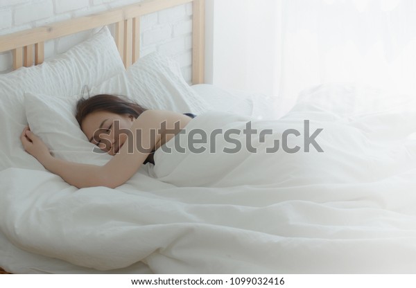 白い部屋のベッドには女が寝ている アジアの女の子が夢見る ベッドの中に寝ている美しい女性 柔らかい枕と暖かい毛布が良い夢を見る 物に集中しないで の写真素材 今すぐ編集
