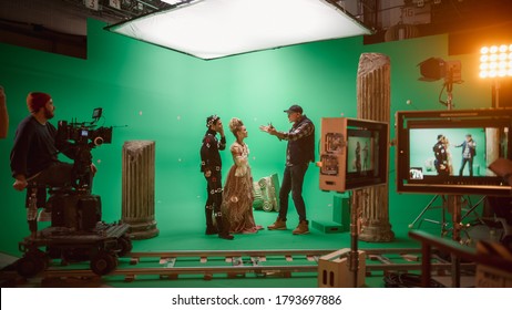 On Big Film Studio Professional Crew Shooting Period Costume Drama Movie. On Set: Director Explains Scene To Woman Actress Playing Renaissance Lady And Actor Wearing Motion Capture Suit