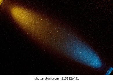 On a black background in fine red grain oncoming yellow and blue rays of light - Shutterstock ID 2151126451