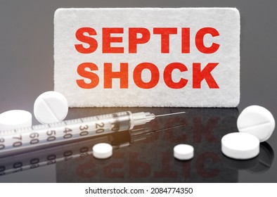 On A Black Reflective Surface, Pills, A Syringe And A Sign With The Inscription - Septic Shock