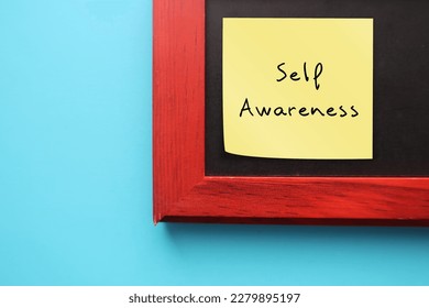 On blue background, photo frame with stick note written SELF AWARENESS, ability to focus on self  to perceive and understand the things that make you who you are as an individual - Shutterstock ID 2279895197