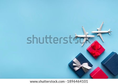 on a blue background, two white airplanes and different boxes with gifts: red with a red bow and blue with a silver bow. The concept of worldwide delivery 