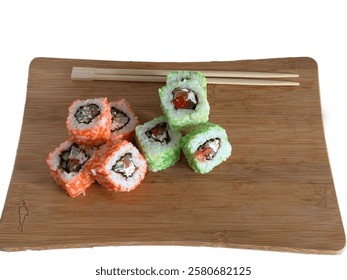 On the board salmon and cheese curd rolls. Sushi delivery with salmon and tuna. Orange and green rolls with chopsticks on a board. Beautiful and tasty sushi.