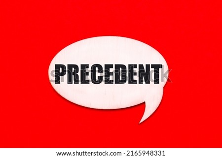 On a bright red background, a light wooden curly card with the text PRECEDENT