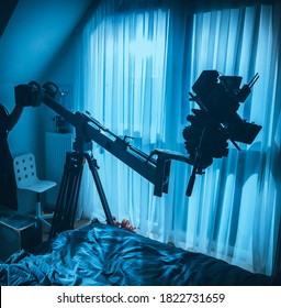 on the camera on a mini crane in the interior against the background of a bright window in a mysterious silhouette