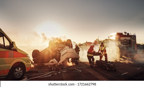 On the Car Crash Traffic Accident Scene: Paramedics and Firefighters Rescue Injured Victim Trapped in the Vehicle. Extricate Person Using Stretchers, Give First Aid and Transport Them to Hospital - Powered by Shutterstock