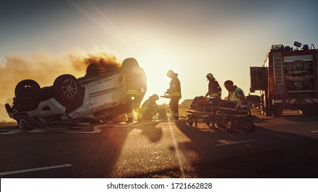 On the Car Crash Traffic Accident: Paramedics and Firefighters Rescue Injured Trapped Victims. Medics give First Aid to Female on Stretchers. Firemen Use Hydraulic Cutters Spreader to Open Vehicle