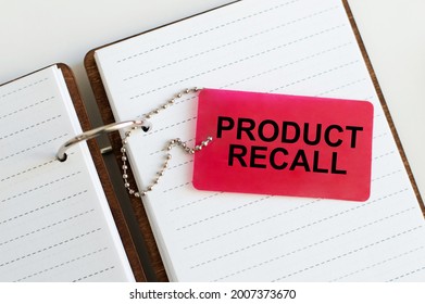 On The Card Text Product Recall Which Lies On An Open Blank Notebook