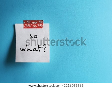 On copy space blue background, stick note with handwritten text SO WHAT?, to express feeling of 