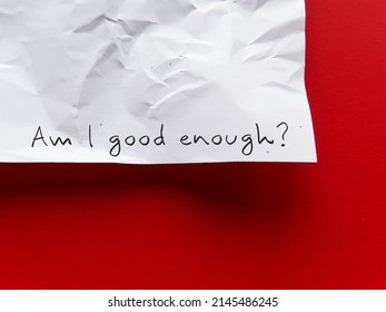 On Copy Space Red Background, Crumpled Paper With Handwritten AM I GOOD ENOUGH? - Negative Self Talk Showing Self Doubt, Inner Voice With Critical Judgement - Feeling Not Good Enough