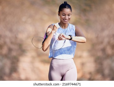 On Course For A New Personal Best. Cropped Shot Of An Attractive Young Female Athlete Checking Her Watch While Running Outside.