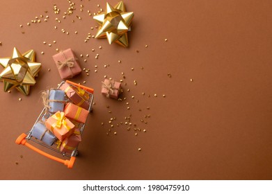 On A Dark Beige Background, Candies, Golden Confetti, Decor. Minimalism. Daylight Illumination. Place For Your Signature. No People. Focus In The Left Corner.