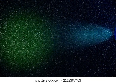 On A Dark Blue Gradient Background, A Ray Of Blue Light Into A Fine Grain With A Transition To A Green Cloud Of Light