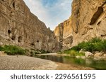 On a day in Springtime, a small stream flows between tall rock walls inside a canyon at Big Bend National Park in Brewster County, TX.