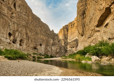 On a day in Springtime, a small stream flows between tall rock walls inside a canyon at Big Bend National Park in Brewster County, TX.