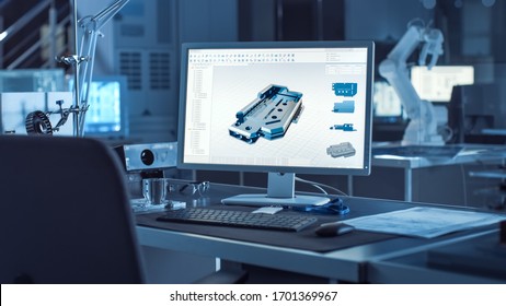 On the Desk Computer With CAD Software and Design of 3D Industrial Machinery Component. In the Background Robot Arm Concept Standing in Heavy the Dark.Industry Engineering Facility.