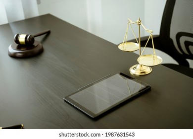 On A Desk No People In A Black-toned Law Office There Was A Tablet Gavel Balance On It.