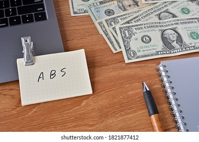 On The Desk There Are Bills, A Keyboard, And Memos With The Word ABS Written On It. It Was An Abbreviation For The Financial Term Asset Backed Security .