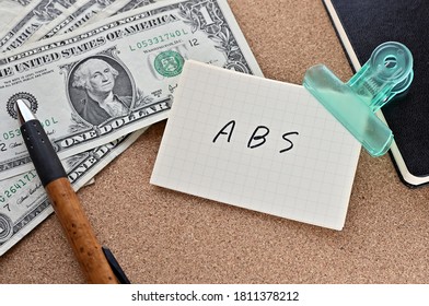 On The Desk Were Bills, A Notebook, And Memos With The Word ABS Written On It. It Was An Abbreviation For The Financial Term Asset Backed Security .