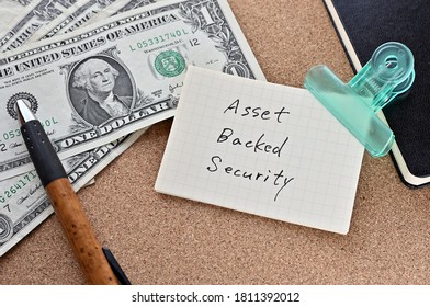 On The Desk Were Bills, A Notebook, And Memos With The Word Asset Backed Security Written On It.