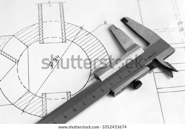 On the detail drawing lies measuring tool\
Vernier caliper. Black and white\
image.