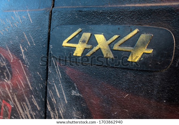 on the dirty car door, the\
four-wheel-drive symbol is two fours. dirty car after driving in\
the mud