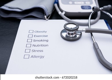 On the doctor's desk, Doctor assess the patient's history and what are the risks to cause a disease with his Diagnose Form. - Powered by Shutterstock