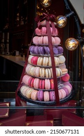 on a etagere are many different colored macarons stacked to a pyramid