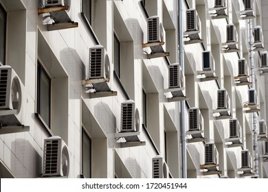 On the facade of the office building there are white air conditioners at the Windows. Concept of indoor climate and air circulation
