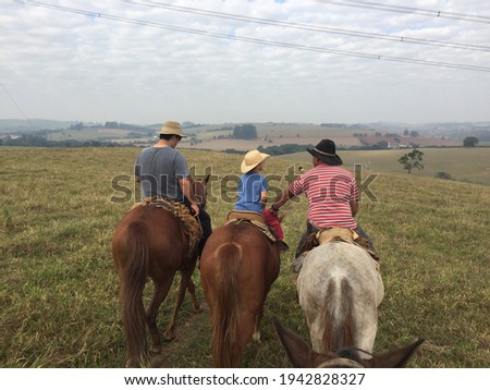 on a farm in the interior of São Paulo riding a horse with a child
