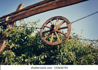 on the fence on chains hanging wooden wagon wheel