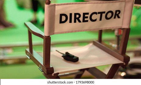 On Film Studio Set Close Up Shot Of Empty Director's Chair. In The Background Professional Crew Shooting Green Screen Scene With Actors For History Movie.