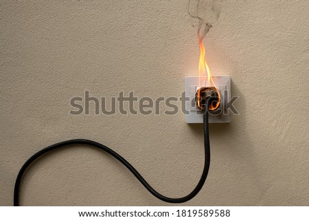 On fire electric wire plug Receptacle on the concrete wall exposed concrete background with copy space