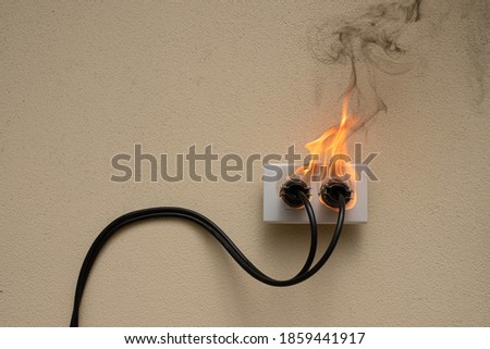 On fire electric wire plug Receptacle on the concrete wall exposed concrete background with copy space