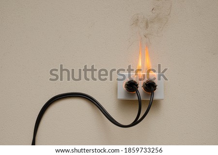 On fire electric wire plug Receptacle on the concrete wall exposed concrete background with copy space
