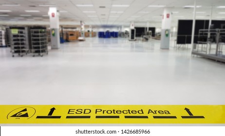 On A Floor Of The Electronics Manufacturing Covered Industrial Linoleum Pastes A Yellow Tape With A Standard Warning Text: 