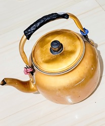 "On The Floor Is A Gold-colored Teapot, Two Wire Ropes Secure The Teapot's Handle For A Grandeur In Ancient Elegance, Exuding An Aura Of Unforgettable Family Memories."