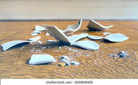 On the floor splinters of a broken plate - Shutterstock ID 1034858428