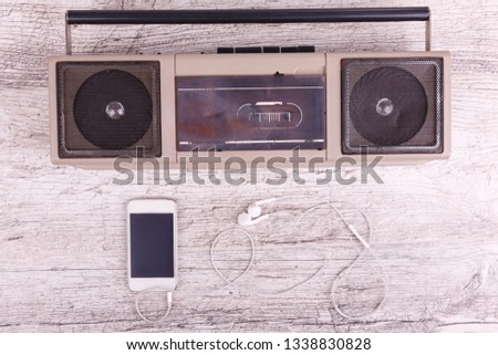 On a gray background cassette recorder phone and headphones
