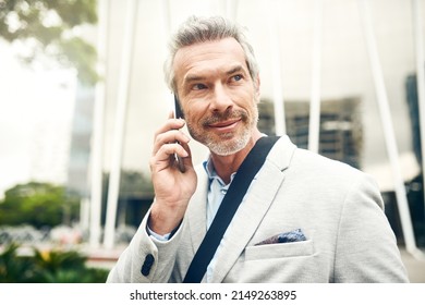 On His Daily Commute. Shot Of A Mature Businessman Talking On A Cellphone In The City.