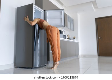 On A Hot Day, The Girl Cools With His Head In The Refrigerator. Broken Air Conditioner.