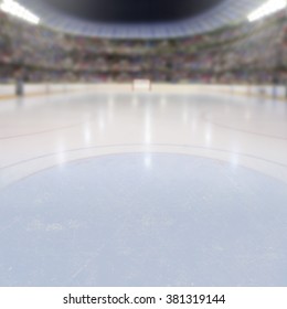On ice low-angle view of a dramatic hockey arena full of fans in the stands with copy space. Deliberate focus on foreground ice and shallow depth of field on background with lighting flare effect.