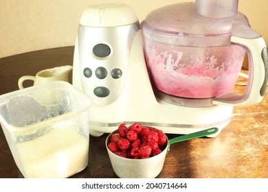 On The Kitchen Counter, A Food Processor Is Stirring Raspberries With Milk. Making A Raspberry Milkshake At Home, Home Mixologist