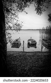 on a lake rowboats lying side by side the shore in water in black white - Shutterstock ID 2224020653
