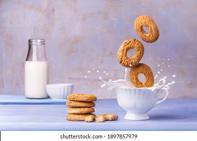 On The Lavender Blue Table, Breakfast Food, Wholemeal Biscuits, Fall Into The Cup Of Milk Generating A Splash