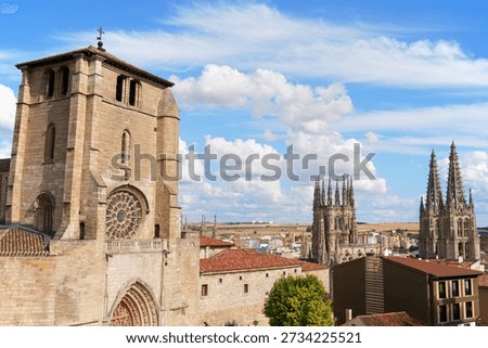On the left: the facade of Saint Stephen Church (Iglesia de San Esteban with its arch in Mudejar style. On the right, Saint Mary of Burgos Cathedral (Santa Maria de Burgos) is a beautiful example of spanish gothic architecture with french influences. Burgos, Castile and León, Spain.